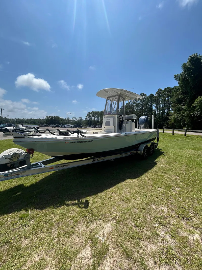 Slide: The Image of 2023 Pathfinder 2300 HPS boat on trailer under clear blue sky. - 33