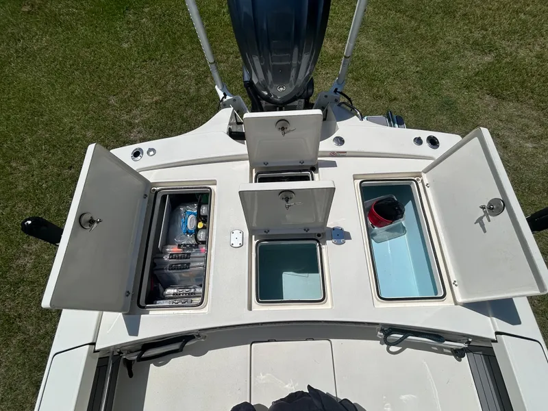 Slide: The Image of 2023 Pathfinder 2300 HPS boat storage compartments open, showcasing organized gear and equipment. - 38