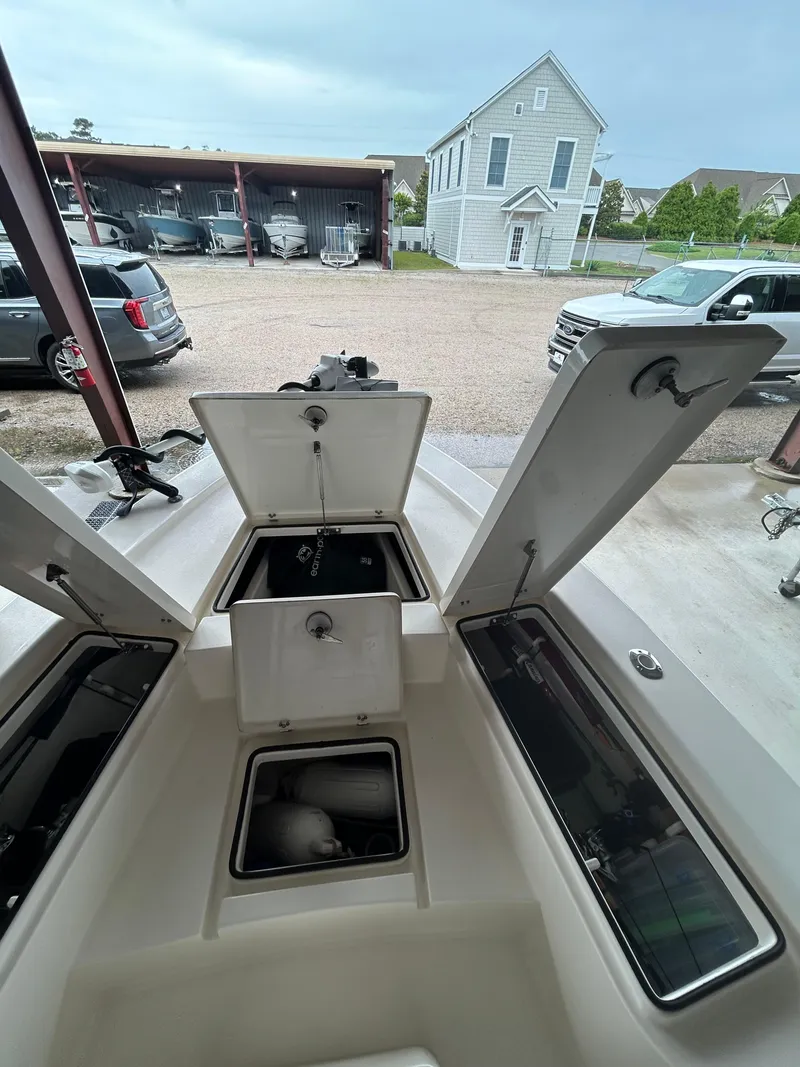 Slide: The Image of 2023 Pathfinder 2300 HPS boat in storage, featuring rod holders and open compartment. - 5
