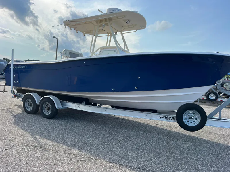 Slide: The Image of 2002 Grady-White Chase 273 boat on trailer, blue hull, parked outdoors under cloudy sky. - 1