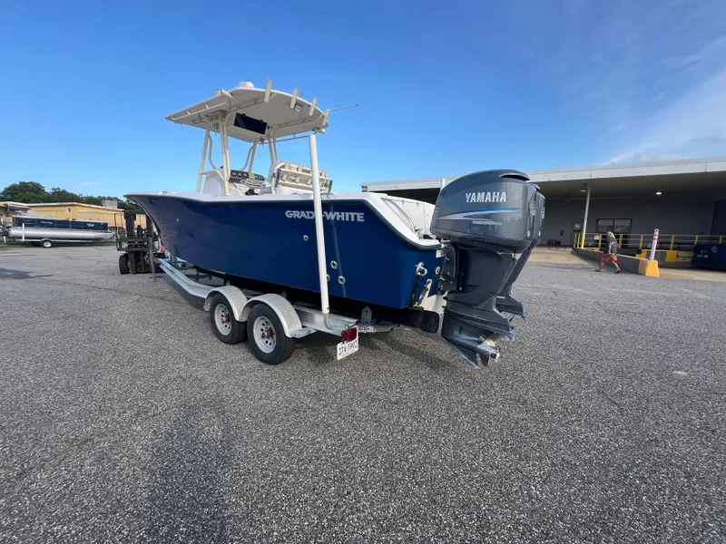 Slide: The Image of 2002 Grady-White Chase 273 boat on trailer, blue hull, parked outdoors. - 14