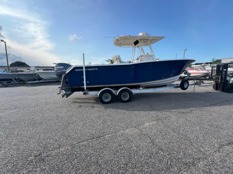 Slide: The Image of 2002 Grady-White Chase 273 boat on trailer, blue hull, parked outdoors. - 15