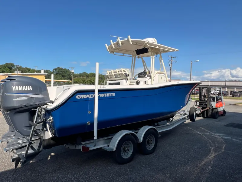Slide: The Image of 2002 Grady-White Chase 273 boat on trailer, parked outdoors under clear blue sky. - 25