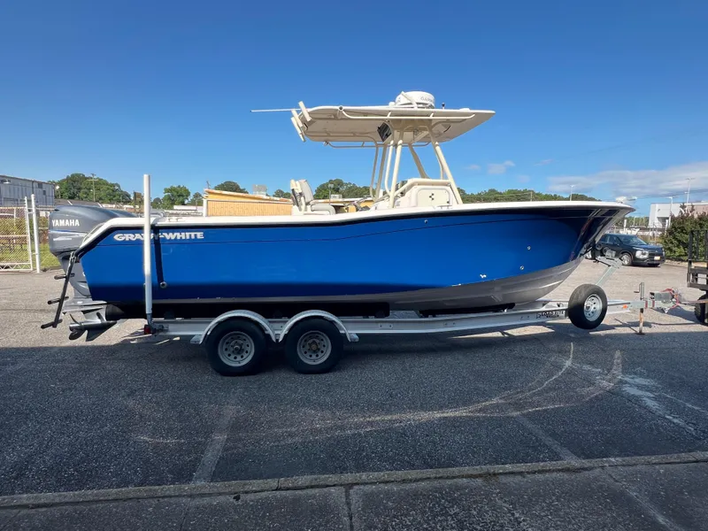 Slide: The Image of 2002 Grady-White Chase 273 boat on trailer, blue hull, parked outdoors. - 26