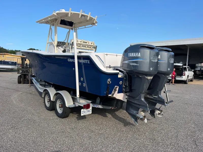 Slide: The Image of 2002 Grady-White Chase 273 boat on trailer, blue hull, parked outdoors. - 7