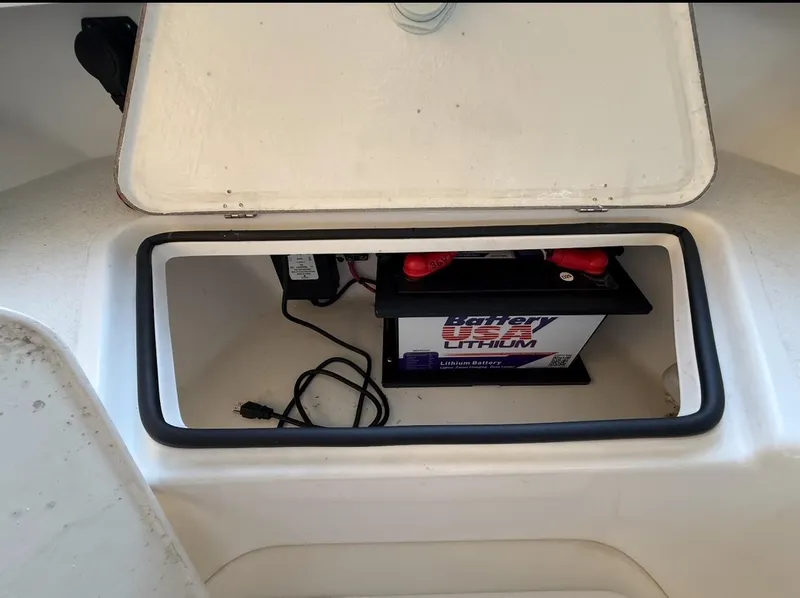 Slide: The Image of Open storage compartment in 2003 Storm Boats 21, revealing a lithium battery inside. - 10