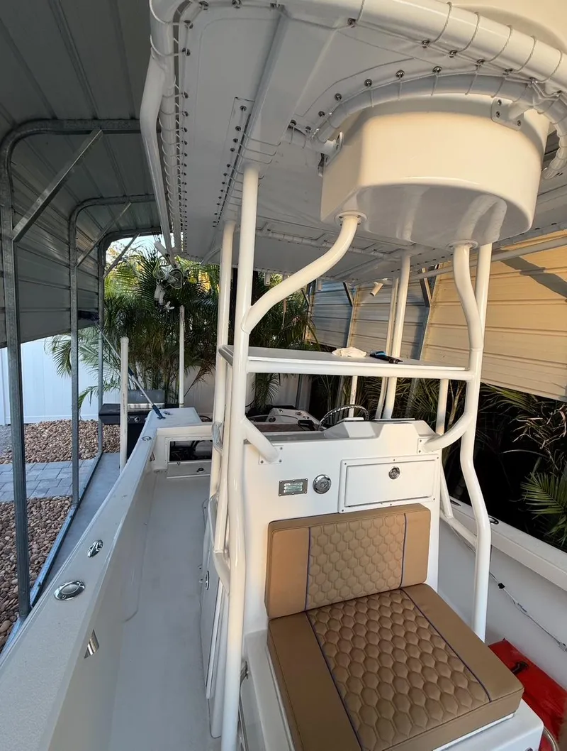 Slide: The Image of 2003 Storm Boats 21 model with cushioned seating and canopy, parked under a shelter. - 2