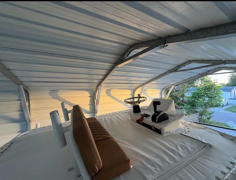 Slide: The Image of 2003 Storm Boats 21 under metal canopy, featuring helm and brown seating. - 3