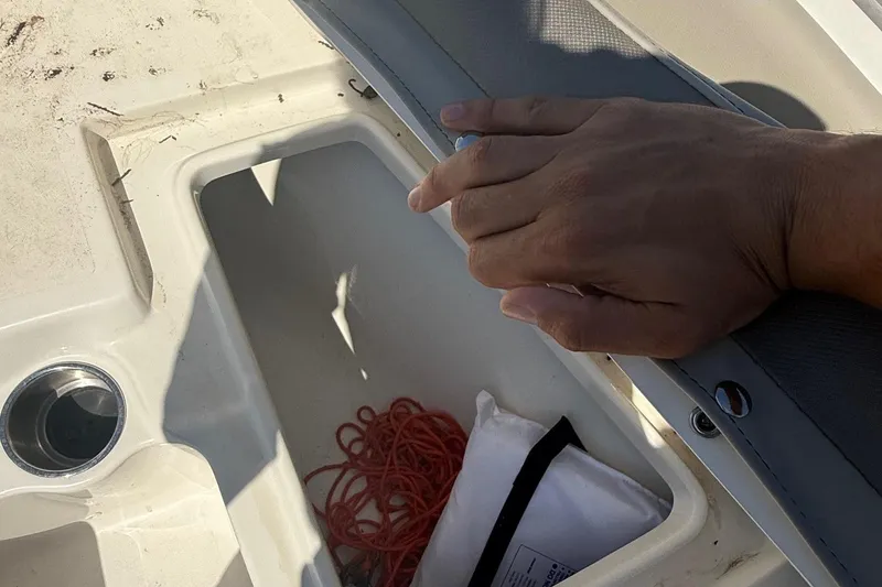 Slide: The Image of Hand opening storage compartment on 2023 Key West 203 FS boat. - 12