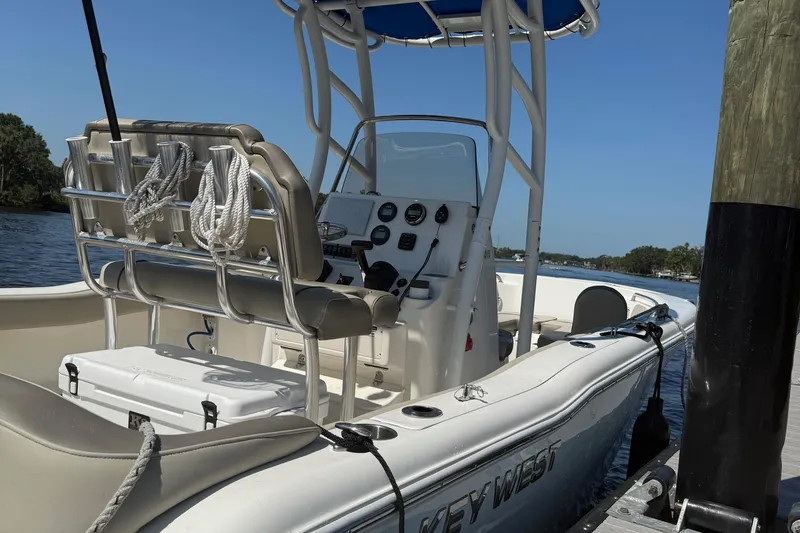 Slide: The Image of 2023 Key West 203 FS boat docked, featuring a sleek console and seating. - 2