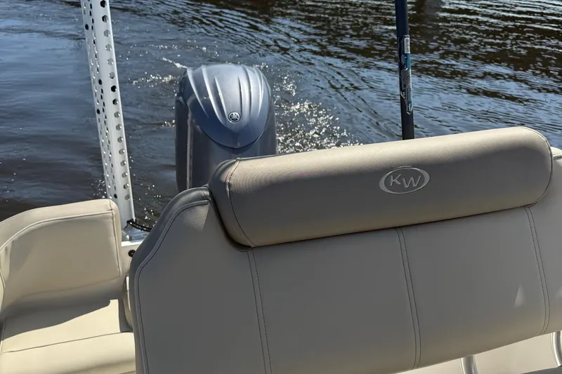 Slide: The Image of 2023 Key West 203 FS boat with beige seating and outboard motor on water. - 24