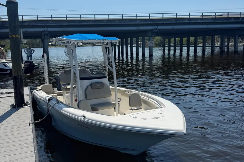 Slide: The Image of 2023 Key West 203 FS boat docked by a bridge, featuring a blue canopy. - 3