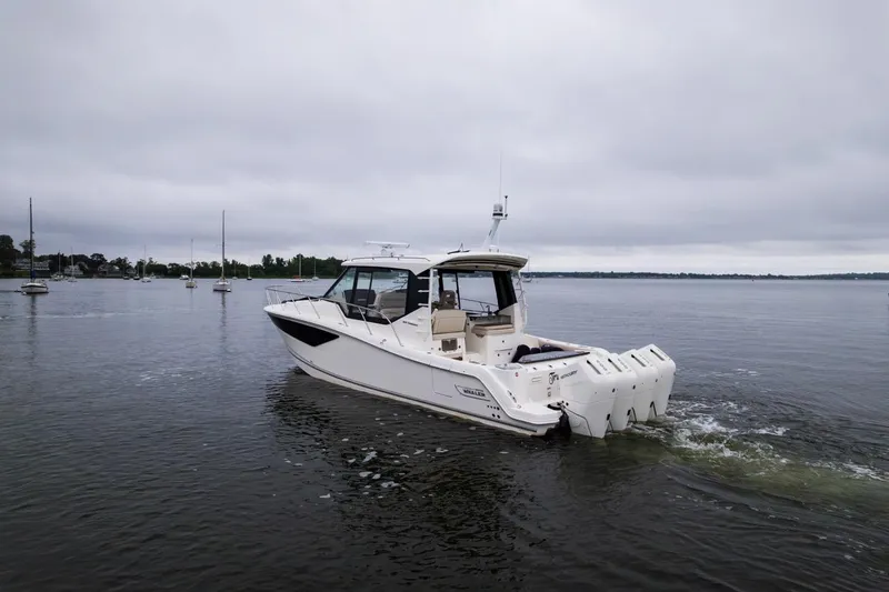 Slide: The Image of 2024 Boston Whaler 405 Conquest boat cruising on a calm lake under cloudy skies. - 10