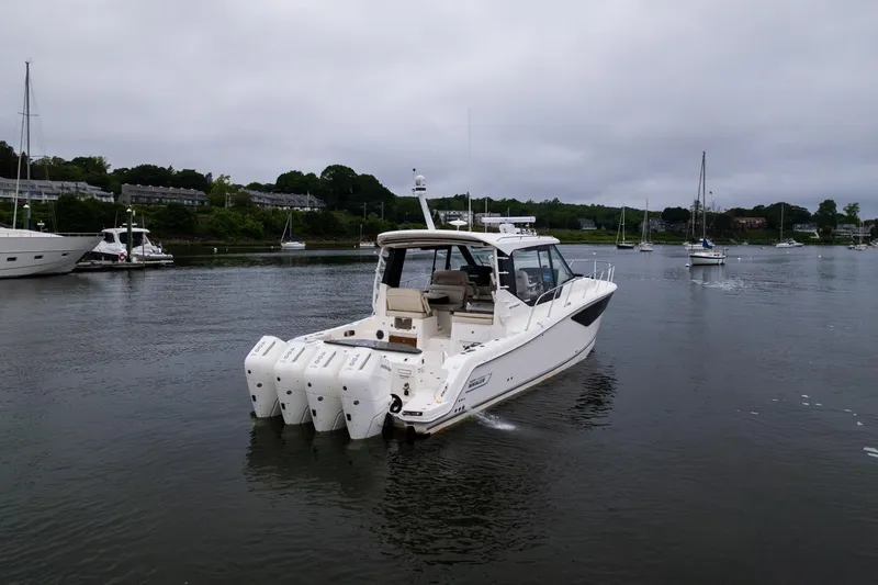 Slide: The Image of 2024 Boston Whaler 405 Conquest boat on calm water, surrounded by other vessels. - 13