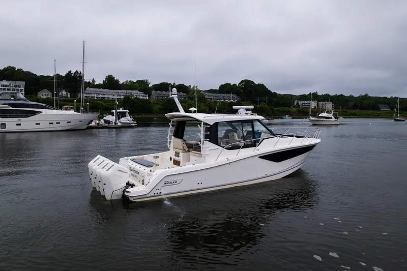 Slide: The Image of 2024 Boston Whaler 405 Conquest boat on calm water, surrounded by other vessels. - 14