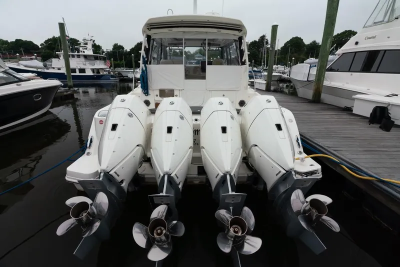 Slide: The Image of 2024 Boston Whaler 405 Conquest with four powerful outboard engines docked at marina. - 16