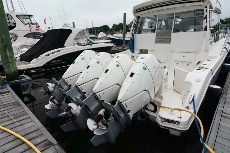 Slide: The Image of 2024 Boston Whaler 405 Conquest with four powerful outboard engines docked at marina. - 17