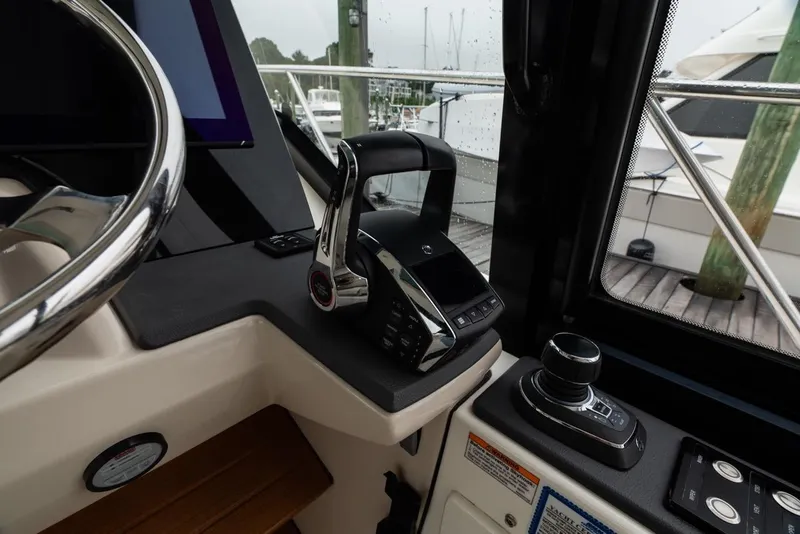 Slide: The Image of 2024 Boston Whaler 405 Conquest helm with modern controls and steering wheel. - 40