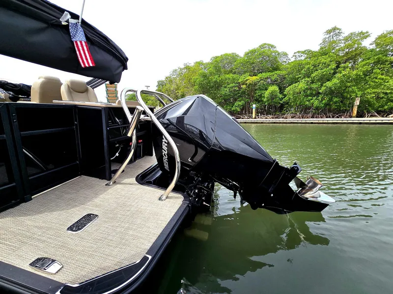 Slide: The Image of 2025 Smoker Craft EXS-3 FD boat with outboard motor on calm water. - 2