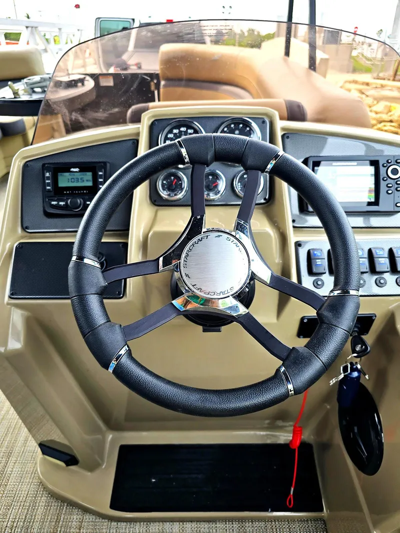 Slide: The Image of Steering wheel and dashboard of 2025 Smoker Craft EXS-3 FD boat, featuring modern controls and gauges. - 6
