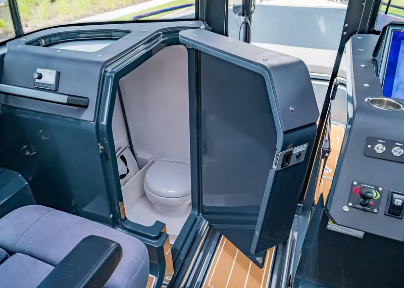 Slide: The Image of 2023 XO Boats EXPLR 9 interior with compact marine toilet and control panel. - 15