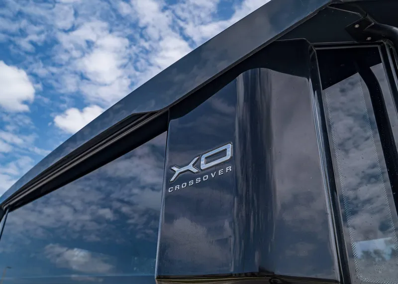 Slide: The Image of 2023 XO Boats EXPLR 9, close-up of logo against a cloudy sky. - 5