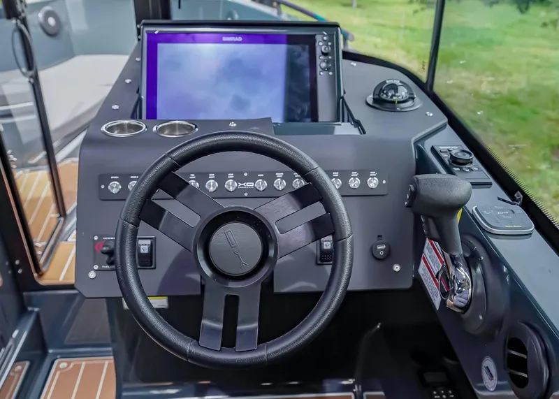 Slide: The Image of 2023 XO Boats EXPLR 9 helm with steering wheel and navigation controls. - 9