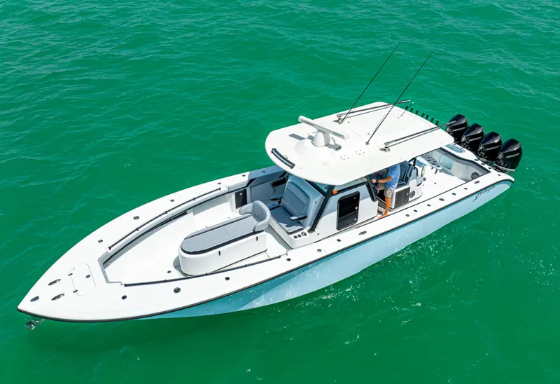 Slide: The Image of 2022 Yellowfin 39 boat on turquoise water, featuring sleek design and multiple outboard engines. - 10