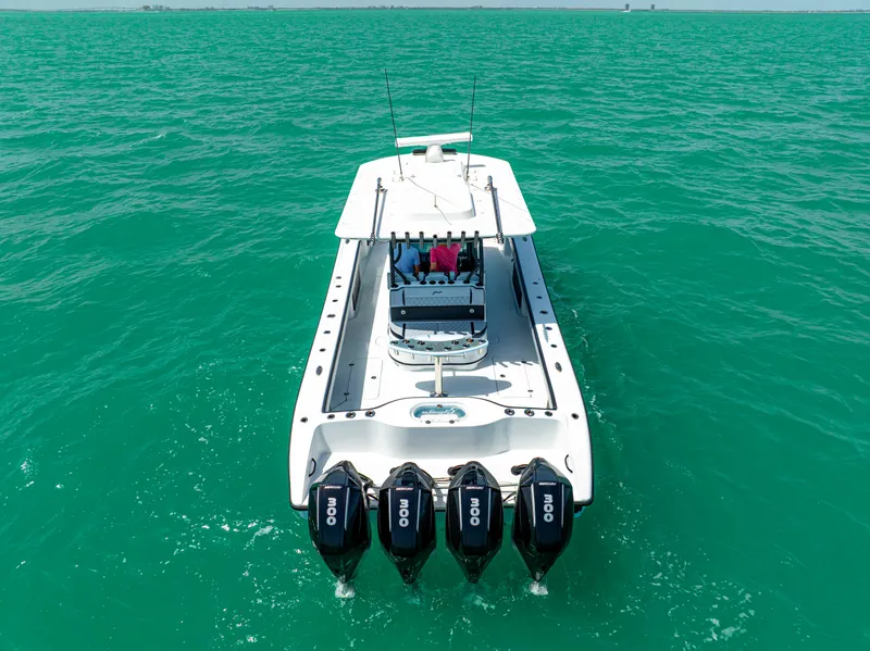 Slide: The Image of 2022 Yellowfin 39 boat with four engines cruising on turquoise water. - 6