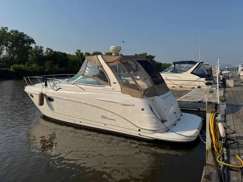 The Image of 2004 Chaparral 290 Signature boat docked at a marina, featuring a beige canopy. - 0
