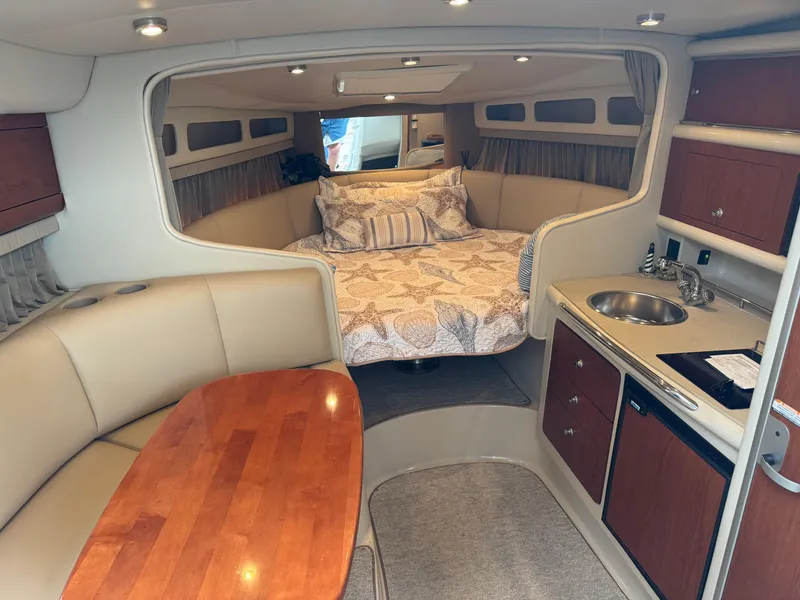 Slide: The Image of 2004 Chaparral 290 Signature cabin interior with bed, kitchenette, and seating area. - 14