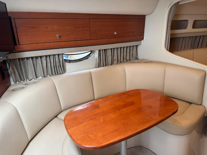 Slide: The Image of 2004 Chaparral 290 Signature cabin with beige seating and wooden table. - 15