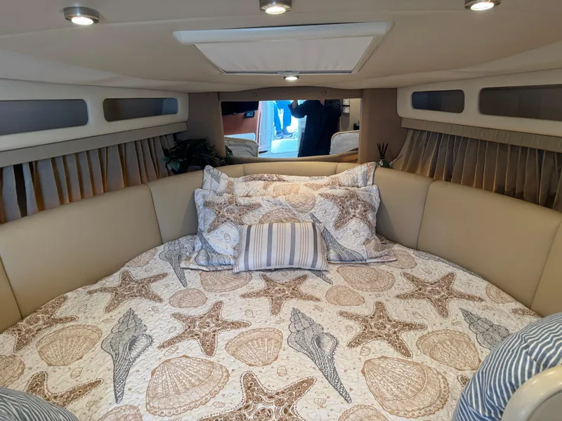 Slide: The Image of 2004 Chaparral 290 Signature cabin with starfish-themed bedding and cozy interior. - 16