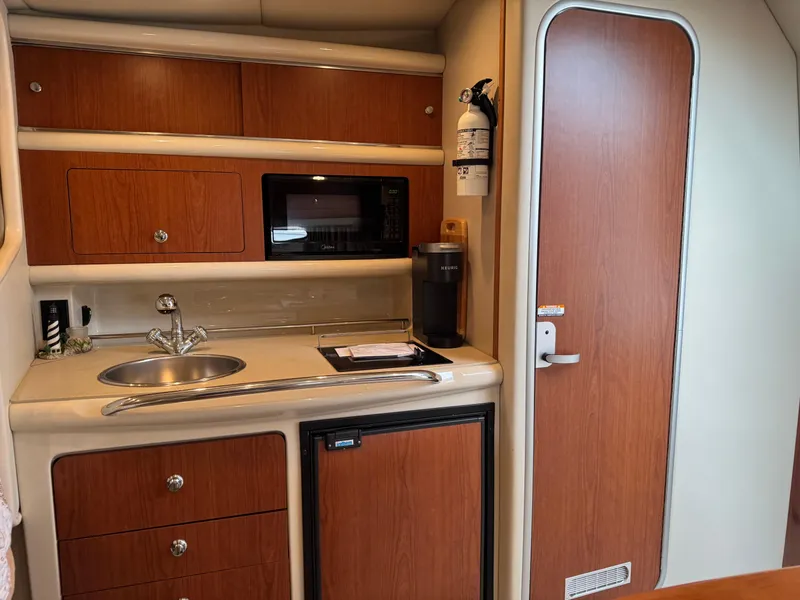 Slide: The Image of 2004 Chaparral 290 Signature boat interior with kitchenette, sink, microwave, and storage cabinets. - 17