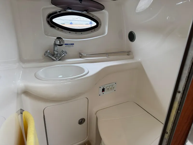 Slide: The Image of 2004 Chaparral 290 Signature boat bathroom with sink, porthole, and compact design. - 18
