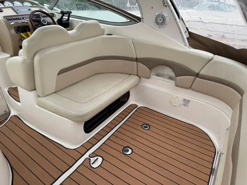 Slide: The Image of 2004 Chaparral 290 Signature boat interior with beige seating and wood-style flooring. - 9