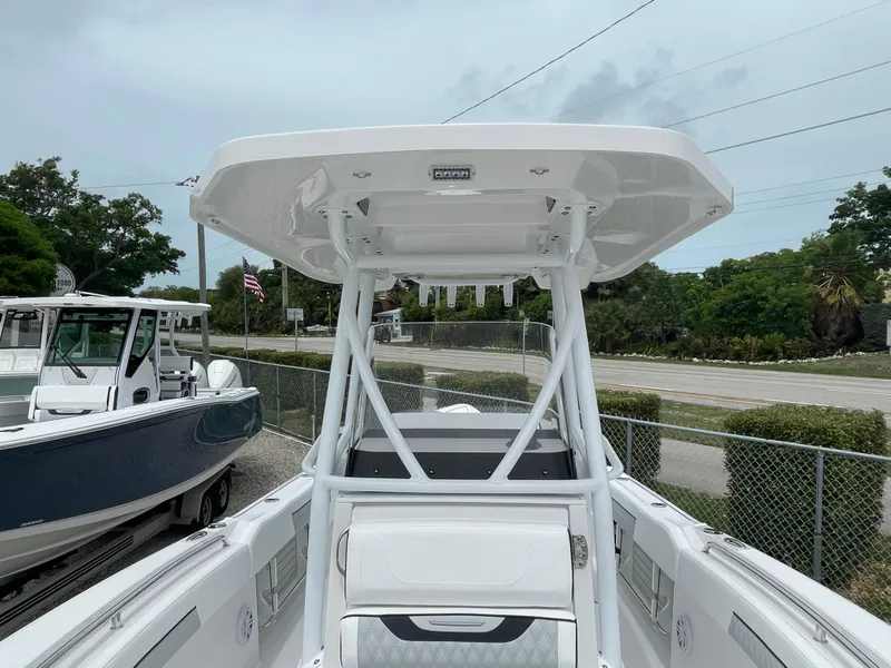 Slide: The Image of 2026 Blackfin 222CC boat with T-top, docked outdoors, showcasing sleek design and modern features. - 11