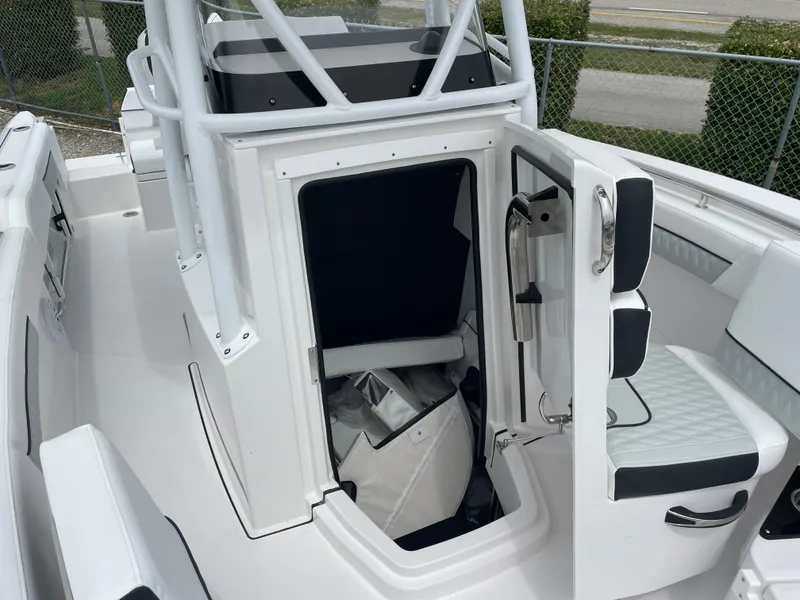 Slide: The Image of 2026 Blackfin 222CC boat interior with open cabin door, showcasing seating and storage. - 12