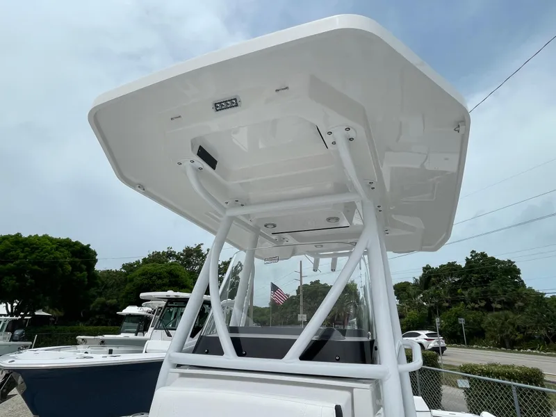 Slide: The Image of 2026 Blackfin 222CC boat with T-top, parked outdoors. - 26