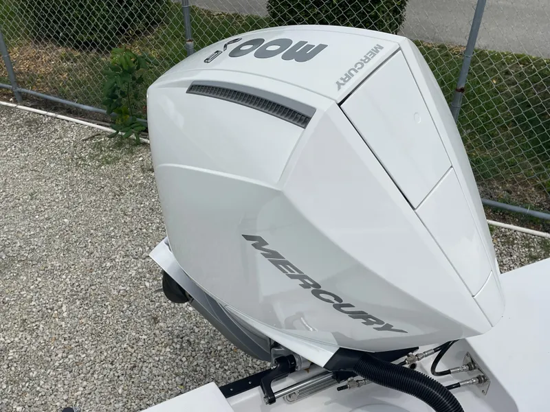 Slide: The Image of 2026 Blackfin 222CC with Mercury outboard engine, parked on gravel near a chain-link fence. - 32