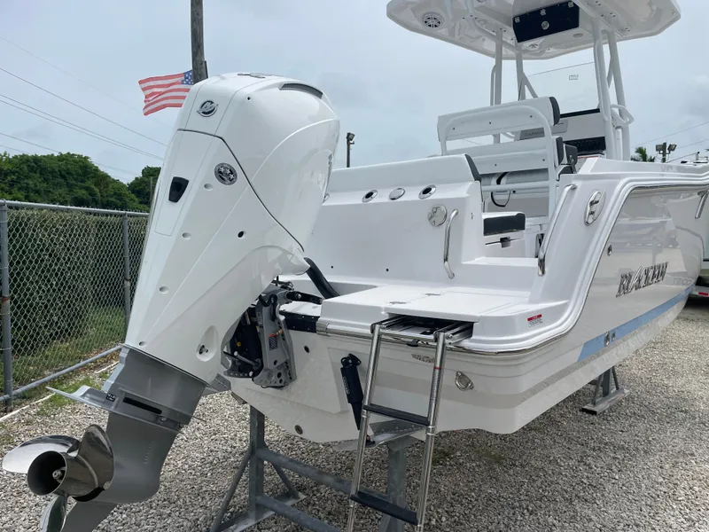 Slide: The Image of 2026 Blackfin 222CC boat with powerful outboard motor and sleek design, parked on gravel. - 34