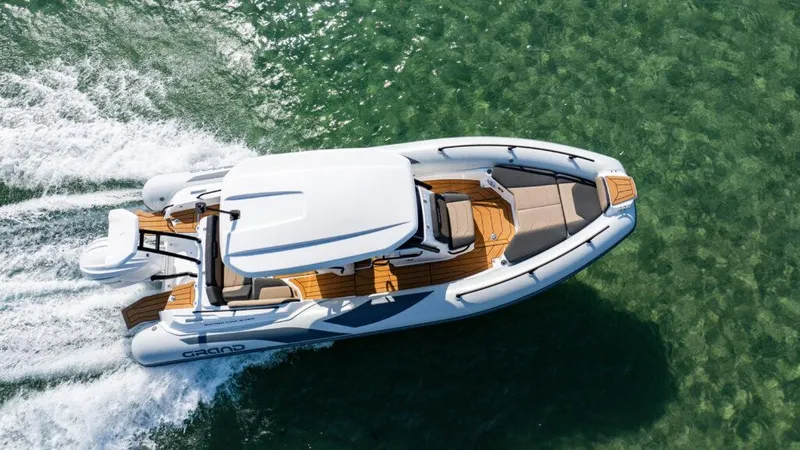 Slide: The Image of 2025 Grand Inflatables G750 boat cruising on clear green water. - 8