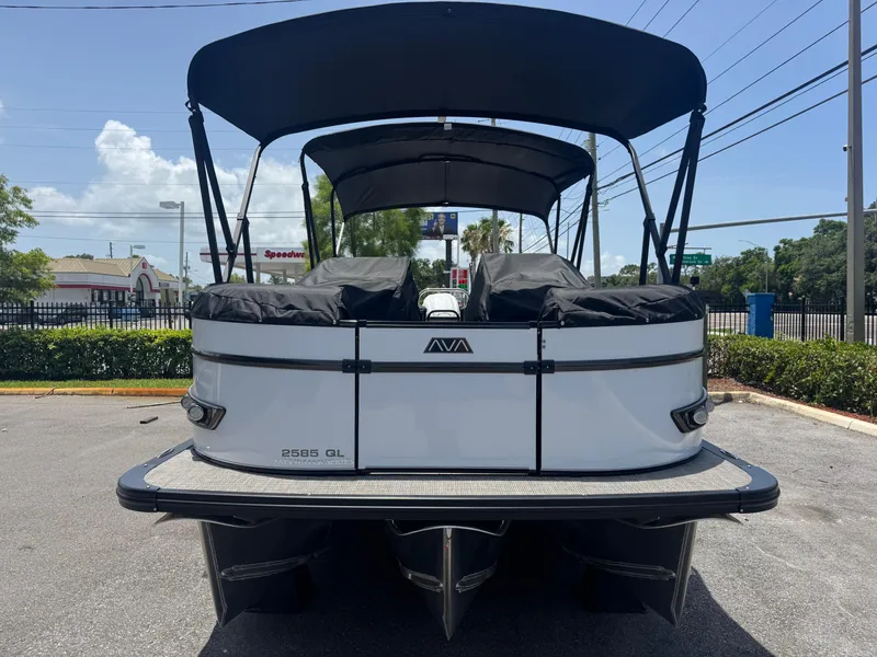 Slide: The Image of 2025 Avalon Catalina Platinum Quad Lounge boat, rear view, parked outdoors under a clear sky. - 13