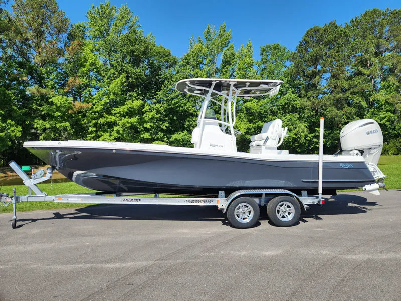 Slide: The Image of 2025 BlackJack 256 Coastal boat on trailer, parked outdoors with trees in background. - 0