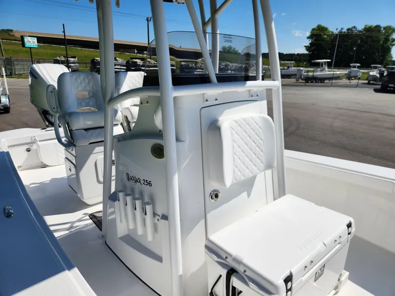 Slide: The Image of 2025 BlackJack 256 Coastal boat interior with seating and console, parked outdoors. - 16