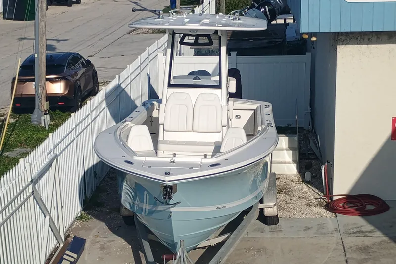 Slide: The Image of 2025 Regulator 23 Center Console boat on trailer near a building. - 3