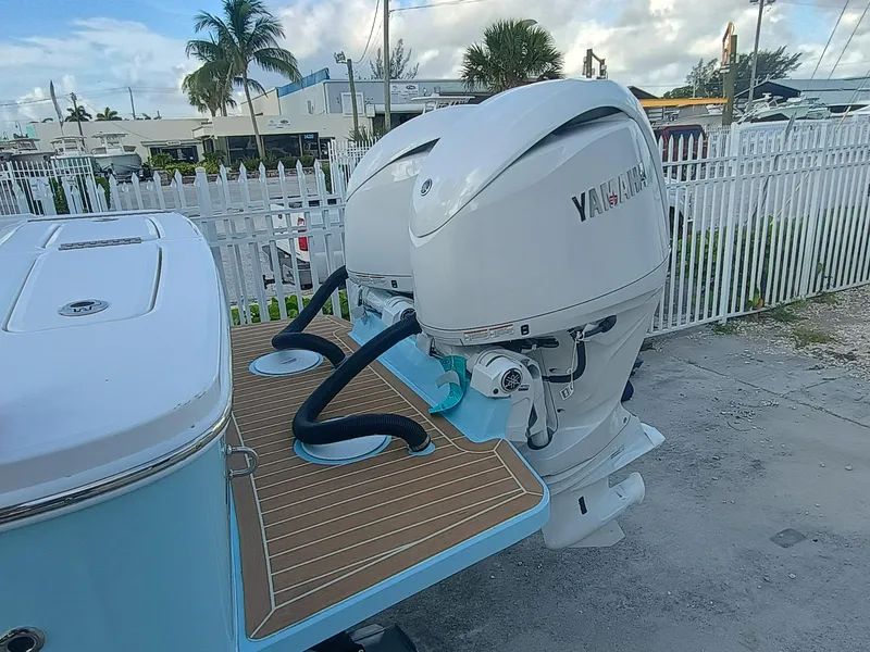 Slide: The Image of 2025 Regulator 23 Center Console with dual Yamaha outboard engines, docked near a white fence. - 32