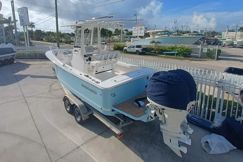 Slide: The Image of 2025 Regulator 23 Center Console boat on trailer, parked outdoors under a clear sky. - 5