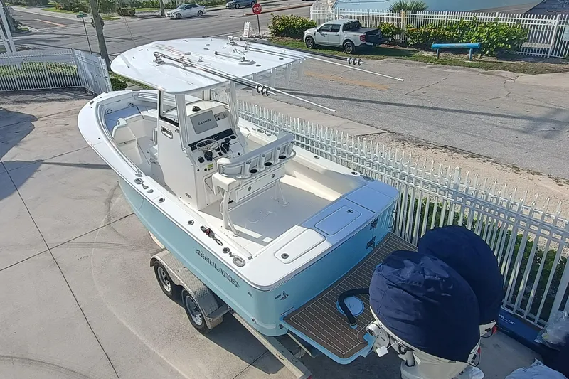 Slide: The Image of 2025 Regulator 23 Center Console boat on trailer, featuring dual engines and spacious deck. - 6
