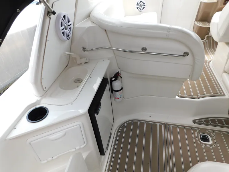 Slide: The Image of 2003 Regal 2860 Commodore boat interior with seating, sink, and wood-patterned flooring. - 18